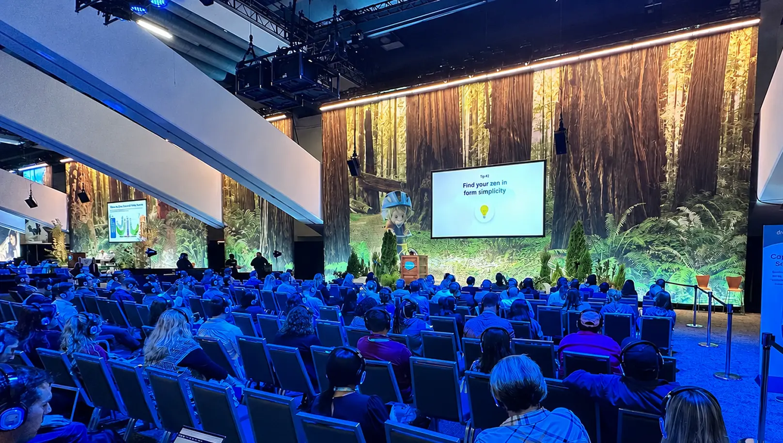 A wide view of the packed keynote audience facing the redwood-forest stage